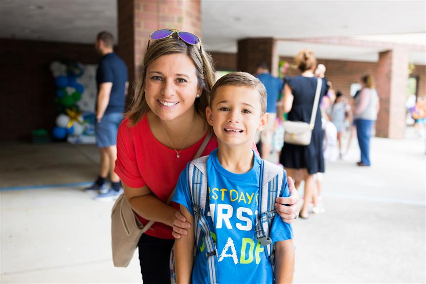 A parent and student smile